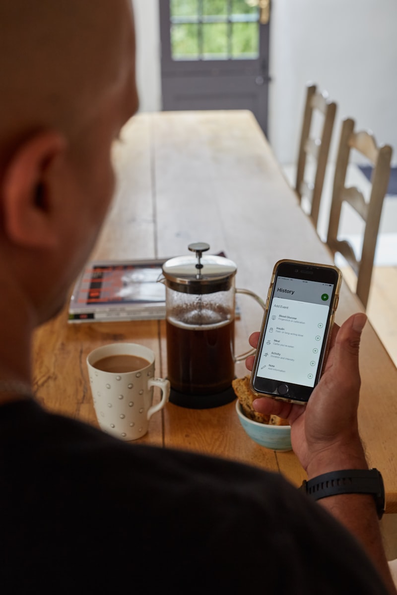 Man reviewing glucose history over breakfast